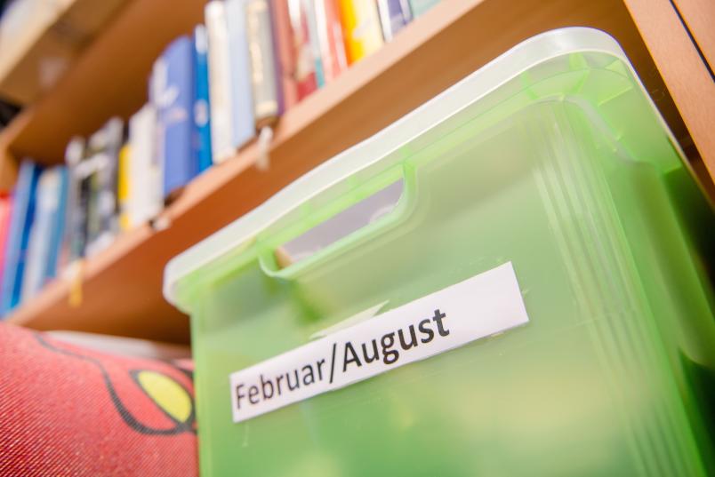 Grüne Kiste in einem Buchregal