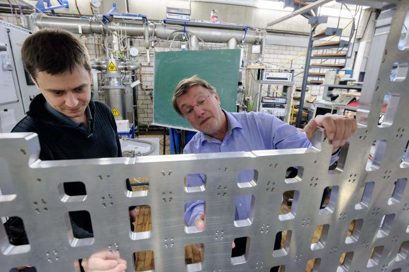 Zwei Forscher begutachten eine große Metallkonstruktion.