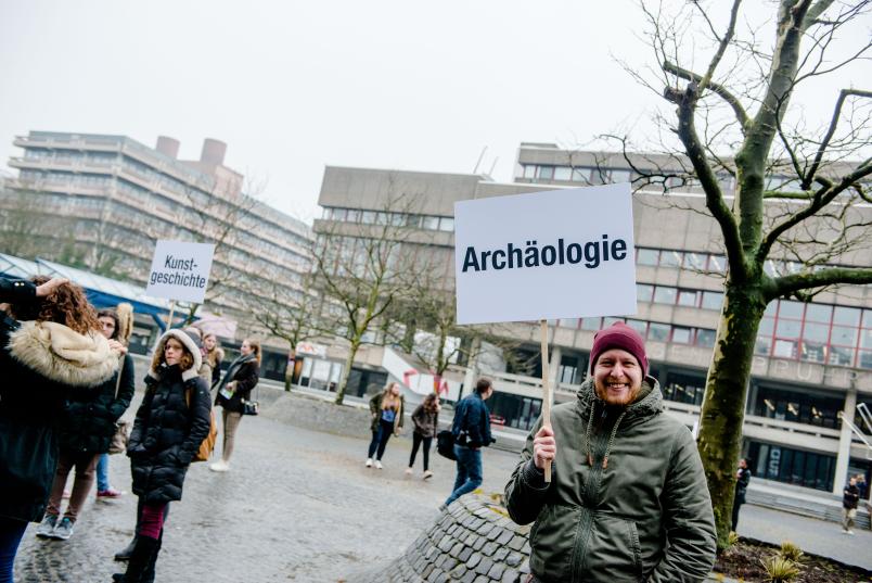 Student mit Schild in der Hand