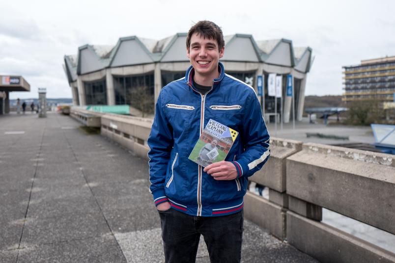 Student hält ein Buch in der Hand.