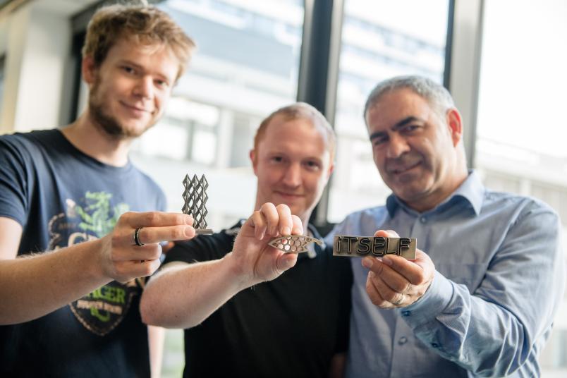 Forscher halten Metallstrukturen in den Händen