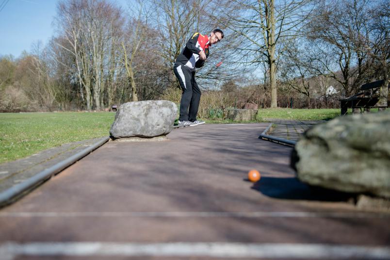 Minigolfspieler schlägt Ball