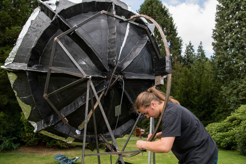 Student schraubt an einem Teleskop.