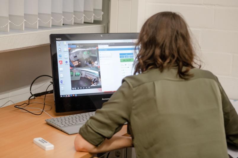 Frau sitzt vor einem PC.