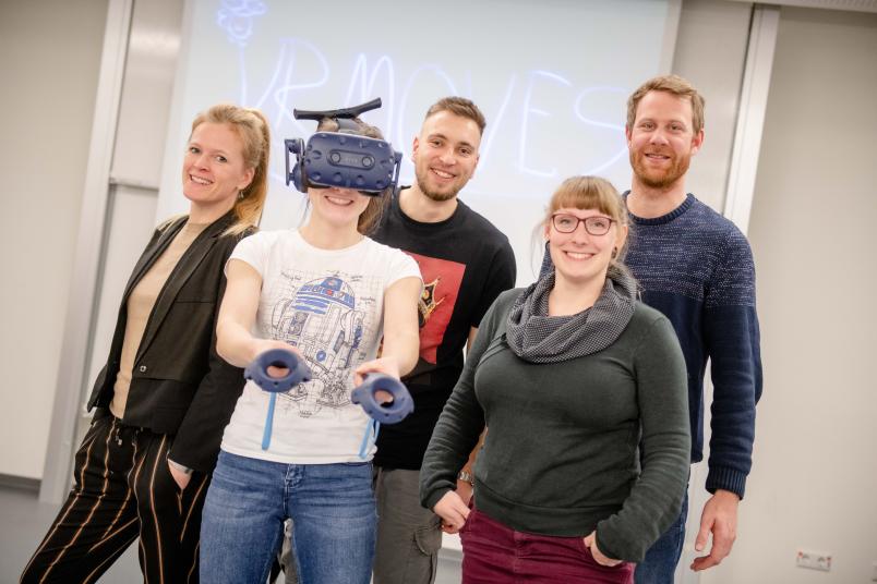 Ein Team aus Forschenden und Studierenden, eine Studentin hat eine VR-Brille auf