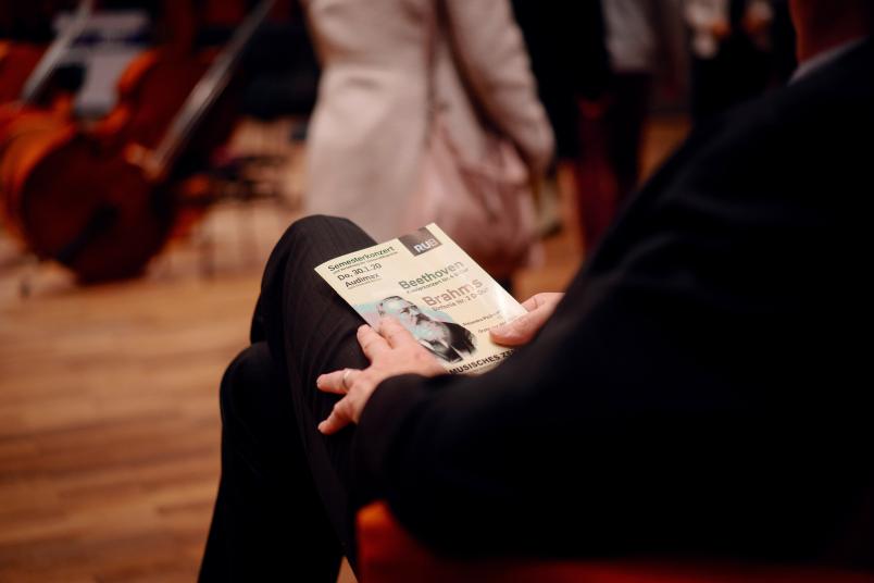 Mann mit Programmheft bei Konzert