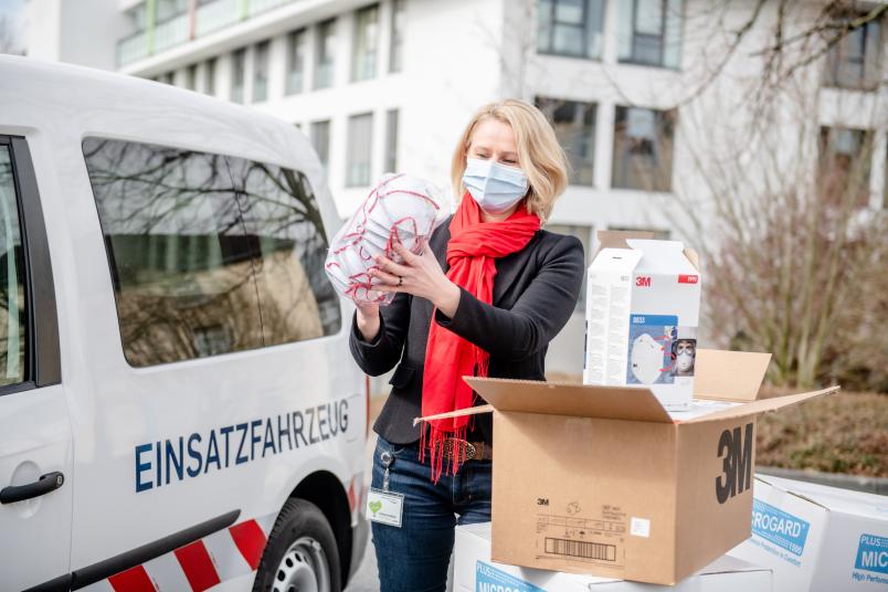 Dr. Irmgard Plößl, Leiterin Einkauf und Apotheke, nimmt am St. Josef-Hospital die Schutzmaterialien aus der RUB entgegen.