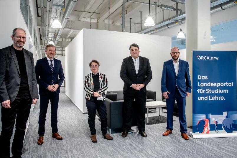 Dr. Markus Deimann, Geschäftsführer der Geschäftsstelle (rechts), und Prof. Berthold Stegemerten von der Hochschule Niederrhein, Sprecher des Lenkungskreises des Landesportals ORCA.nrw (links) mit dem Staatssekretär und der RUB-Spitze