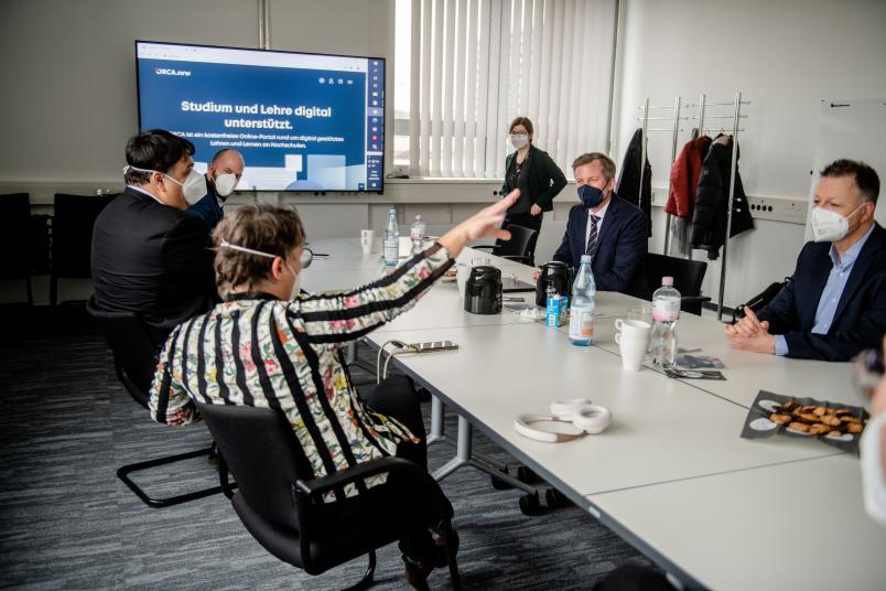 Im Gespräch mit dem Staatssekretär (2. von rechts) erläuert die Kanzlerin die Rolle der RUB bei der Digitalisierung der Lehre.