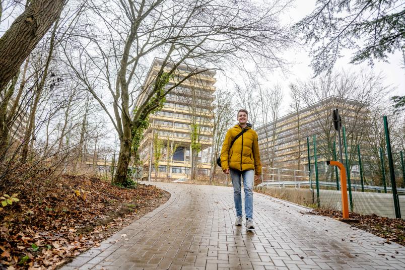 Max Lucks läuft einen Weg herunter. Hinter ihm ist die G-Reihe zu sehen.