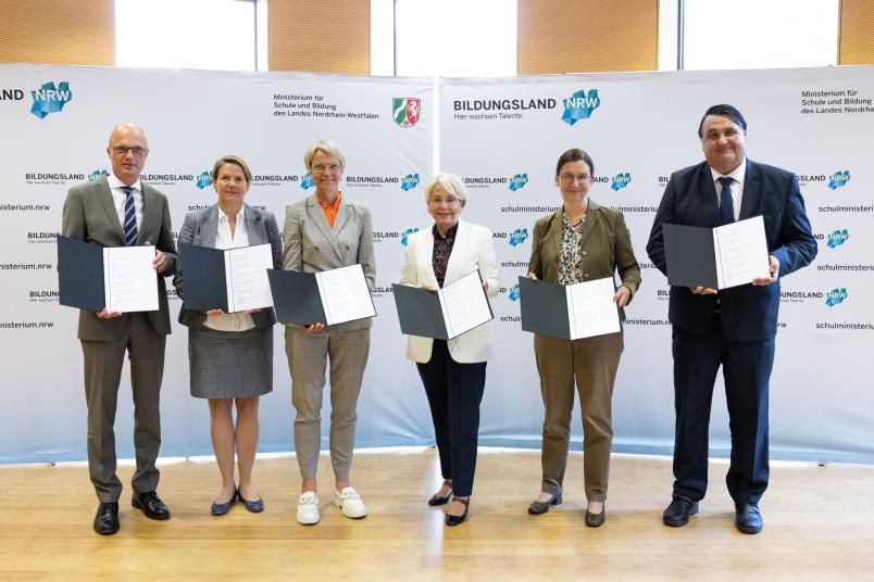 Gruppenbild der Partnerinnen und Partner mit dem unterzeichneten Letter of Intent im NRW-Schulministerium