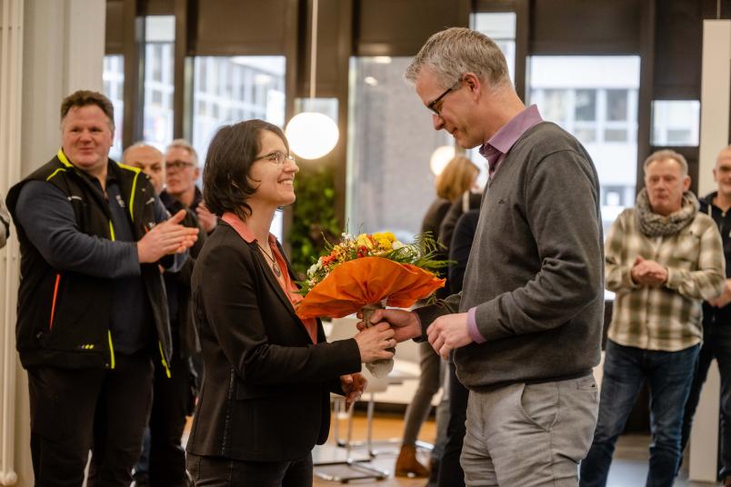 Architektin Judith Grocholl bekommt von Dezernent Robert Grosche Blumen überreicht.