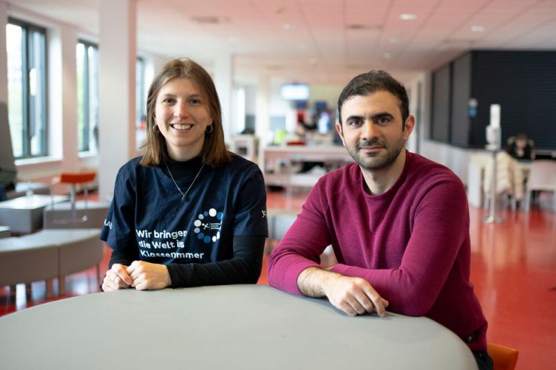 Hanna Schömann und Behnam Ghazinouir sitzen in der Cafete. 