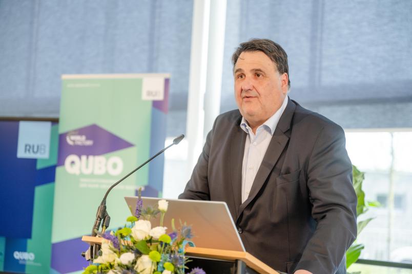 Rektor Prof. Dr. Martin Paul steht an einem Rednerpult auf der Bühne und hält eine Rede.