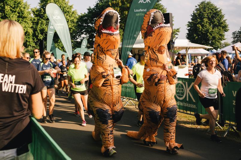 Zwei als Dinosaurier verkleidete Läufer