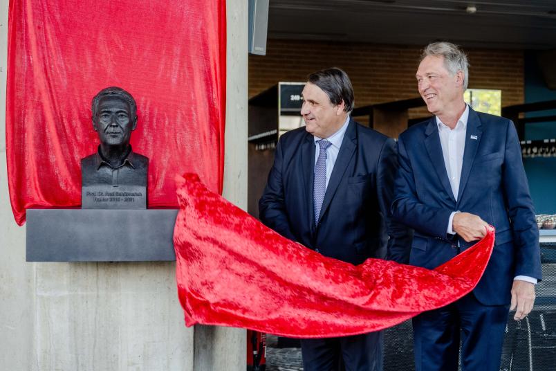 Rektor Martin Paul (links) und Axel Schölmerich enthüllen die Büste im Foyer des Audimax.