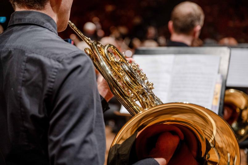 Bild vom letzten Semesterkonzert. Ein Mann spielt ein Blasinstrument. 