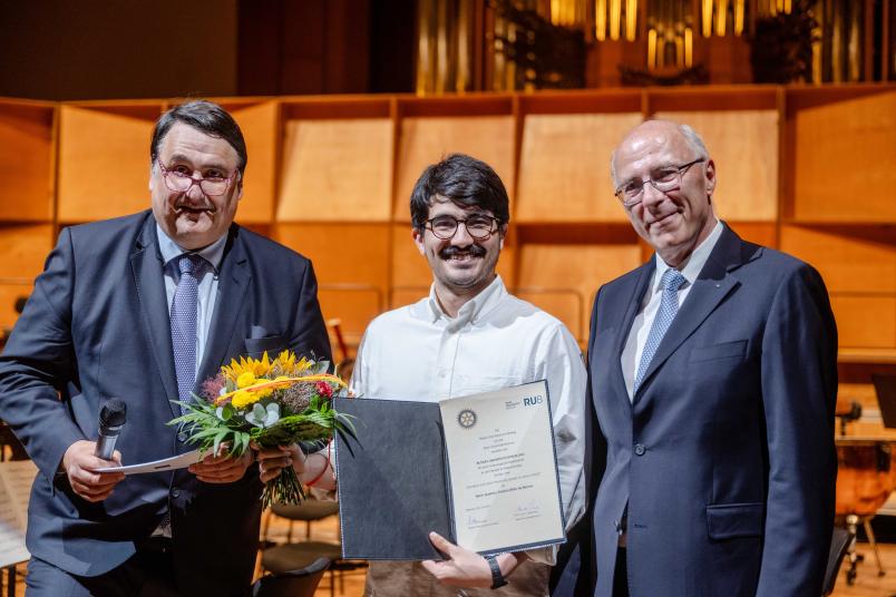 Gustavo Tenório Brito de Barros (Mitte) hat den Rotary-Preis Bochum Hellweg erhalten, überreicht vom Rotary-Präsidenten Prof. Dr. Volkmar Nicolas (rechts) und von Rektor Prof. Dr. Martin Paul.
