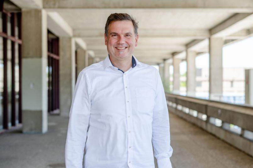Ein Foto von Professor Doktor Jan-Hendrik Kamplage auf dem Campus der Universität.