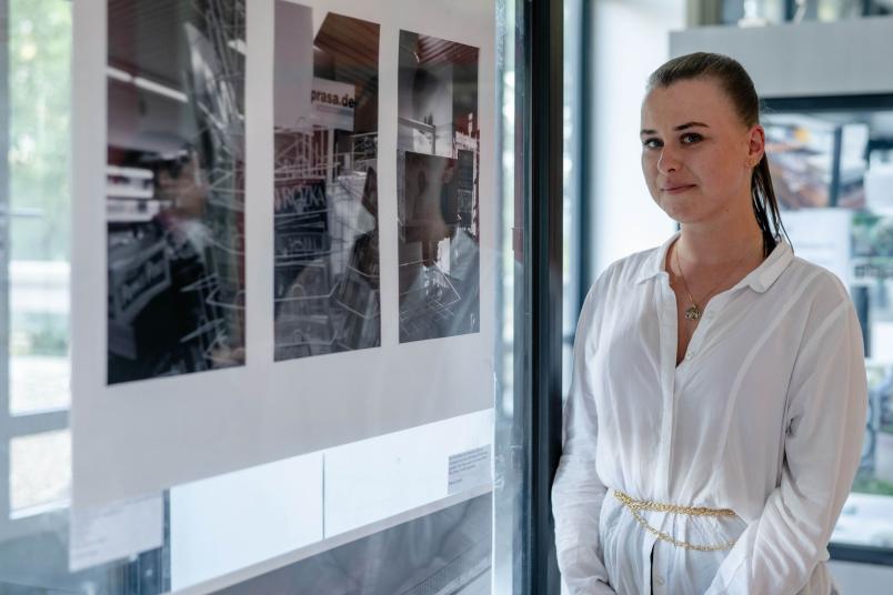 Eine Studentin vor Schaukasten mit Foto: Michelle Bialek