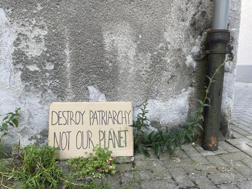 Protestschild steht auf dem Boden.