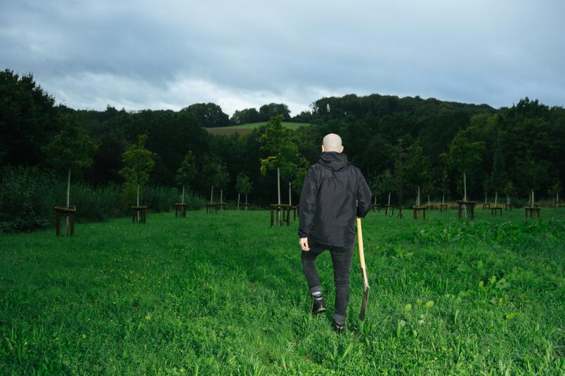 Mann geht über eine Wiese