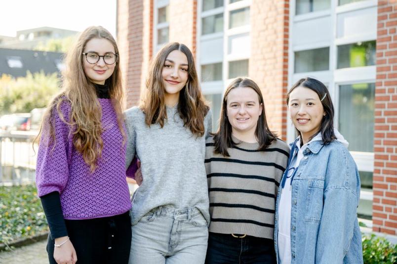 Gruppenbild mit vier jungen Frauen. Sie stehen nebeneinander. 