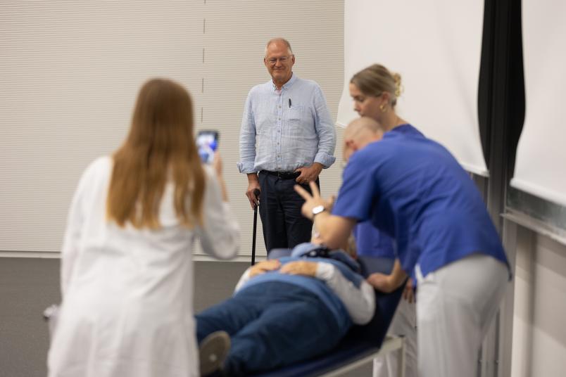 Mehrere Personen in Medizinkleidung mit einem Patienten