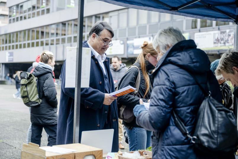 Rektor steht an einem Infostand