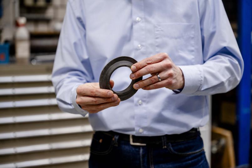 Eine Person hält einen metallischen Ring in den Händen