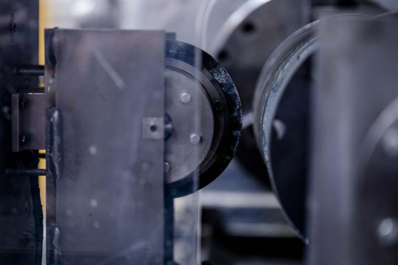 Ein zylinderförmiger Gesteinskörper und ein metallischer Schneidring reiben in einer Drehbank aneinander