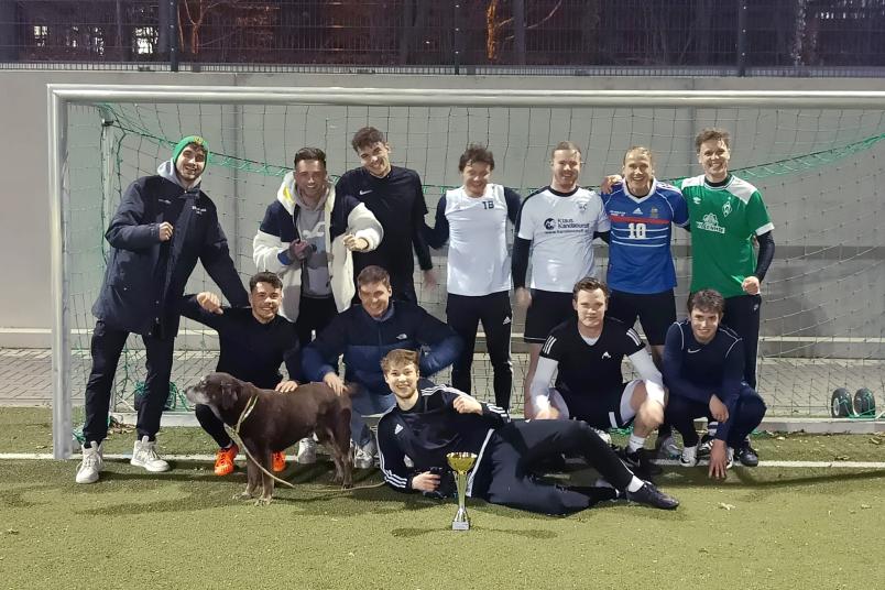 Fußballteam mit Pokal und Hund