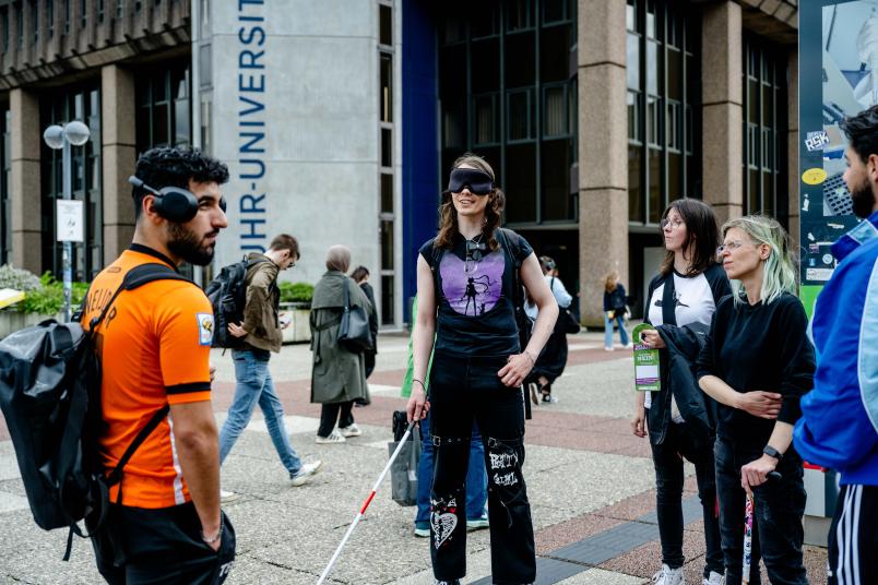 Mensch mit verbundenen Augen und Blindenstock