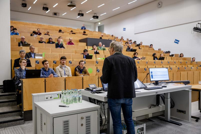 Günther Meschke begrüßt Menschen im Hörsaal