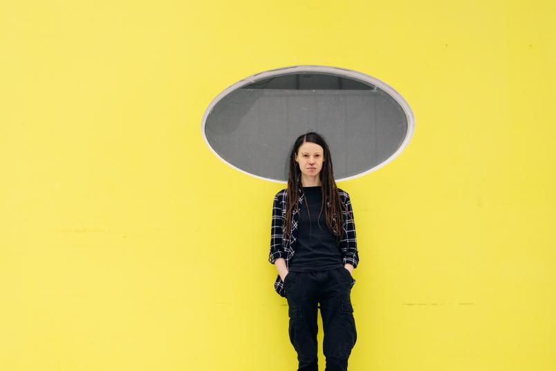 Porträt einer Person vor einer gelben Wand