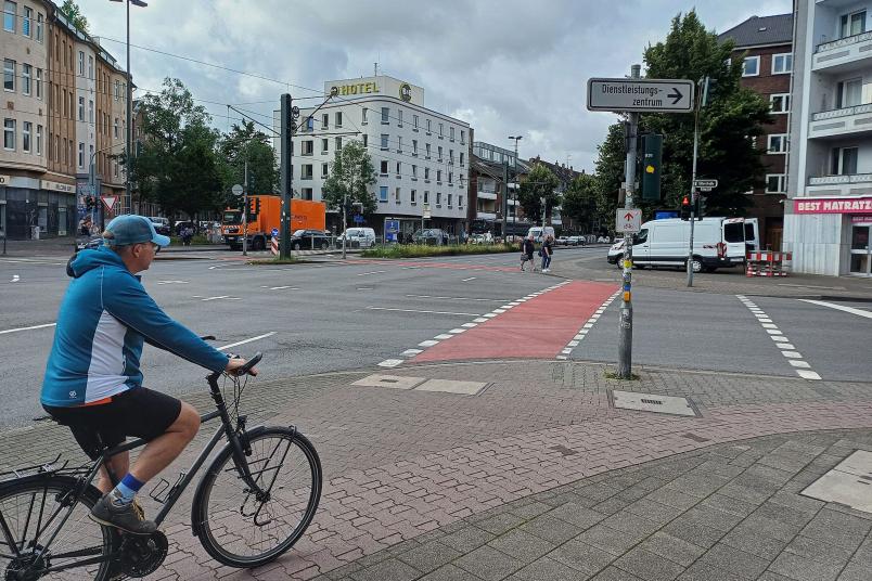 Radfahrer fährt auf eine rote Radfuhrt zu