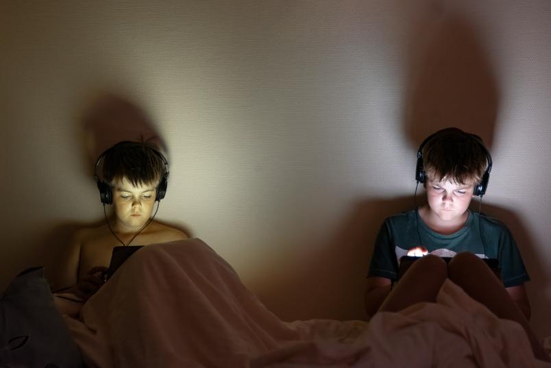 Zwei Kinder mit Tablets und Kopfhörern