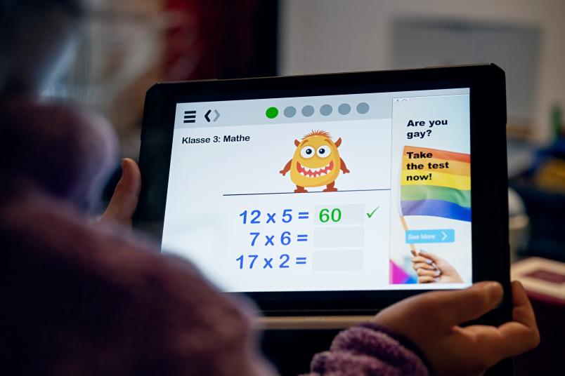 Tablet mit Einmaleins-Rechenaufgabe, daneben eine Werbeanzeige für einen Test auf Homosexualität.