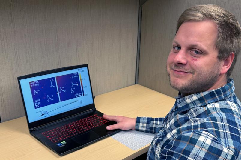 Forscher mit einem Laptop, der wissenschaftliche Grafiken zeigt