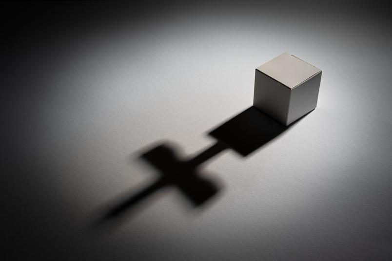 Kästchen, das einen kreuzförmigen Schatten wirft
