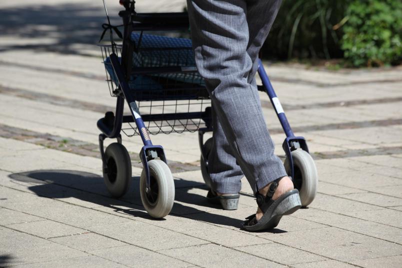 Person, die einen Rollator schiebt
