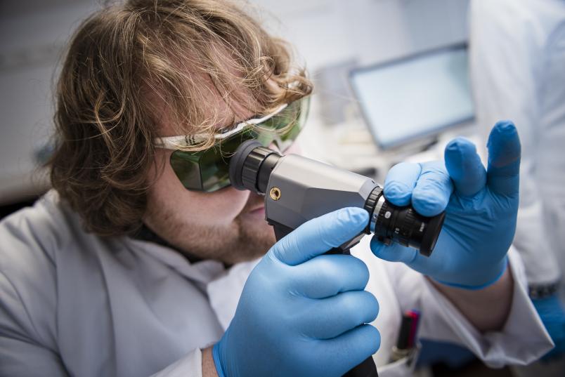 Ein Mann schaut in ein optisches Gerät