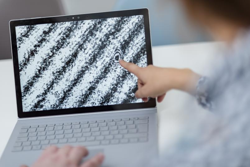 Ein Finger zeigt auf einen schräg gestreiften Monitor