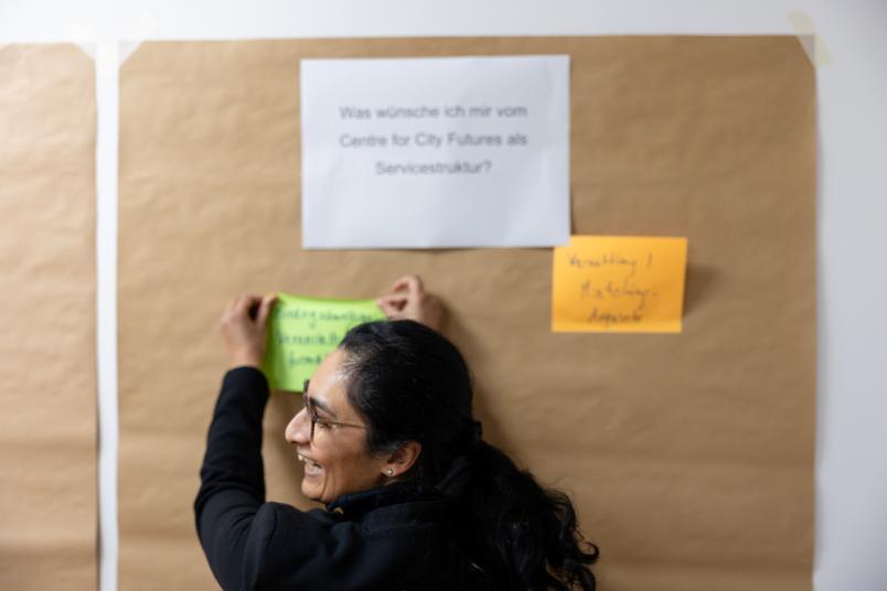 Frau schreibt an eine Pinnwand