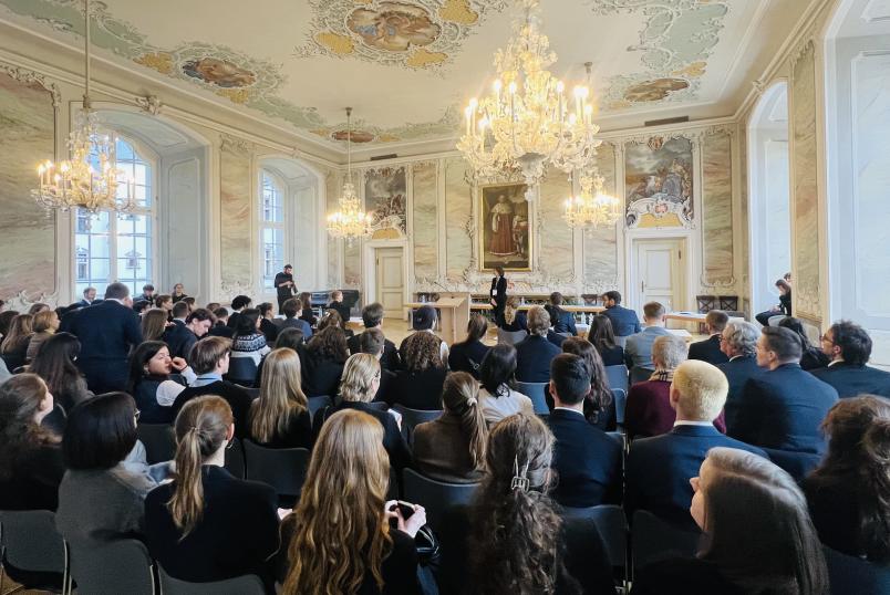 Vollbesetzter Saal mit Kronleuchtern