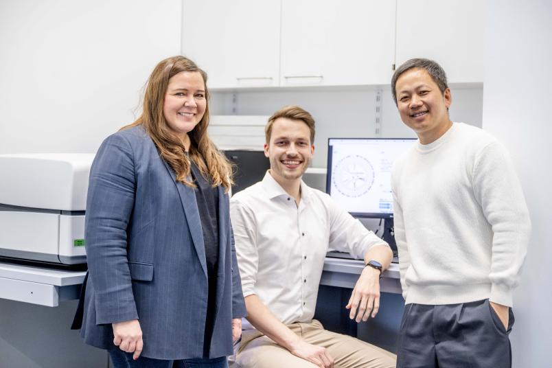 Drei Personen sitzen in einem Labor