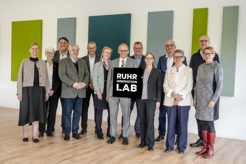 Gruppenfoto der Bochumer und Dortmunder Rektorate mit großem Ruhr-Innovation-Lab-Logo