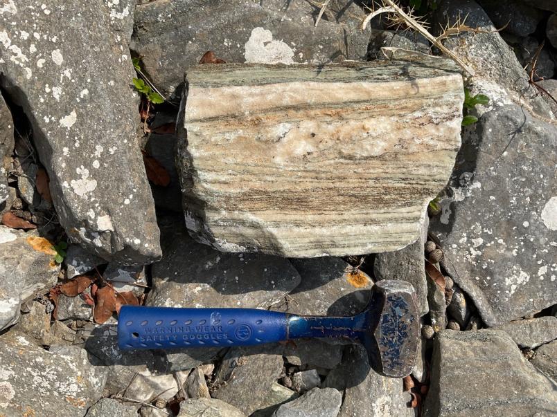 Ein blauer Hammer liegt auf Steinen