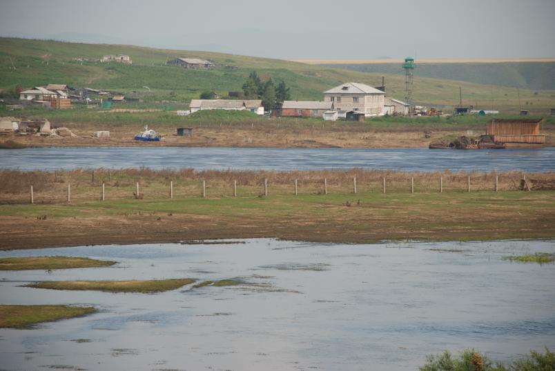 Karge Wiesen mit Wasser und vereinzelten Häusern