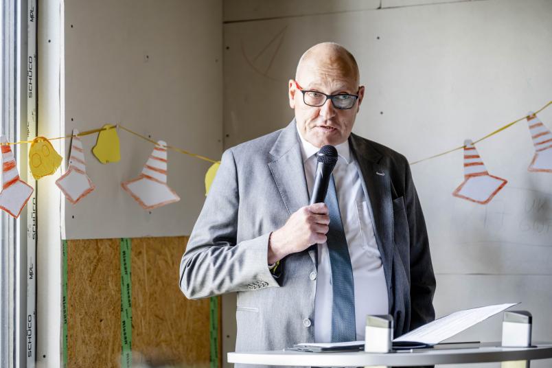 AKAFÖ-Geschäftsführer Frank Weeke steht am Rednerpult mit einem Mikrofon in der Hand.